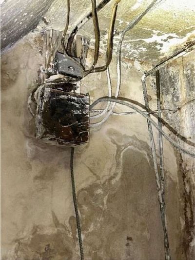 Holes in the garage ceiling exposing pipes and framing above, an incomplete fire barrier in a converted Fern Rock Philadelphia rowhome, documented during a home inspection