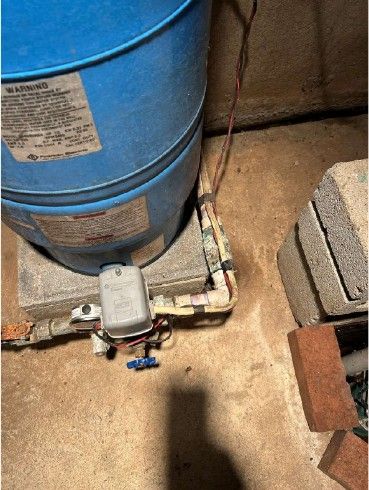 Corroded and leaking well water supply line at a blue pressure tank in a Phoenixville Chester County PA basement, found during a July 2026 home inspection