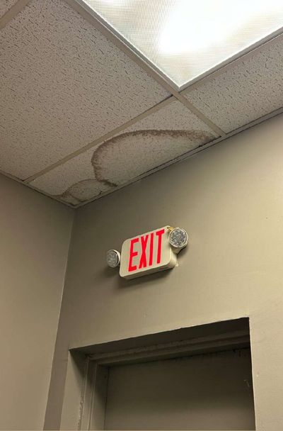 Water staining on a ceiling tile above the back exit door in a commercial office suite in Aston, PA, documented during September 2026 mold testing