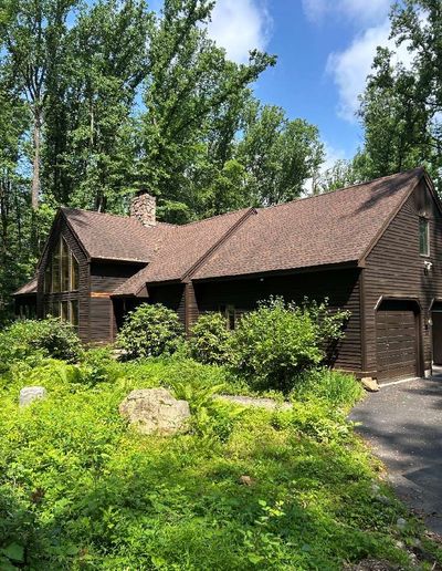 Exterior view of a single-family home in Schwenksville PA inspected in June 2026 — wooded property with attached garage and mature landscaping