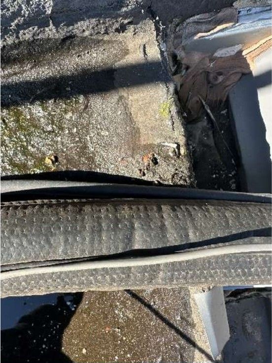 Standing water on a flat roof with improper flashing on a Northeast Philadelphia rowhome during a home inspection