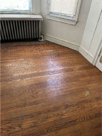 Cast-iron radiator on hardwood flooring in a 1945 Logan / Fern Rock North Philadelphia rowhome heated by a boiler system, documented during a June 2026 home inspection