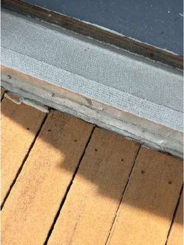 Deteriorated flat-roof membrane section beneath the rooftop deck of a Port Richmond Philadelphia rowhome, documented during a June 2026 home inspection