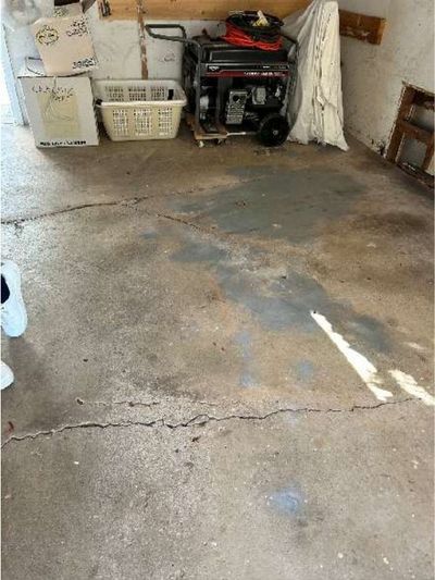 Cracked and settled attached garage floor slab in a 1960s Warminster PA home, documented during a June 2026 home inspection