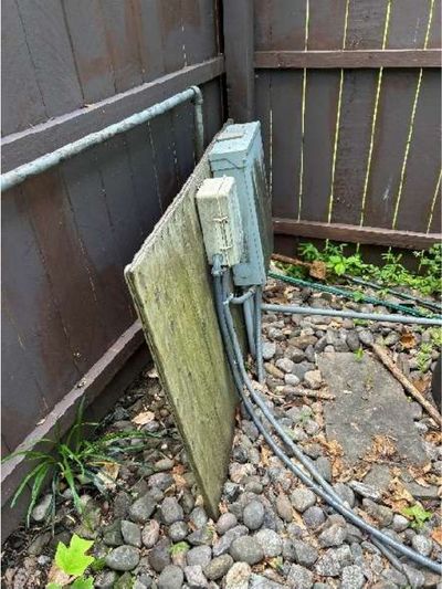 Unsecured pool electrical panel leaning loose against a fence at a Schwenksville PA pool home, found during a June 2026 home inspection