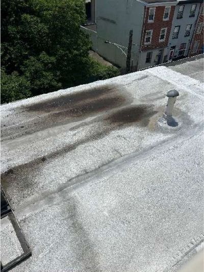 Standing water and ponding on the flat roof of a Port Richmond Philadelphia rowhome, found during a June 2026 home inspection