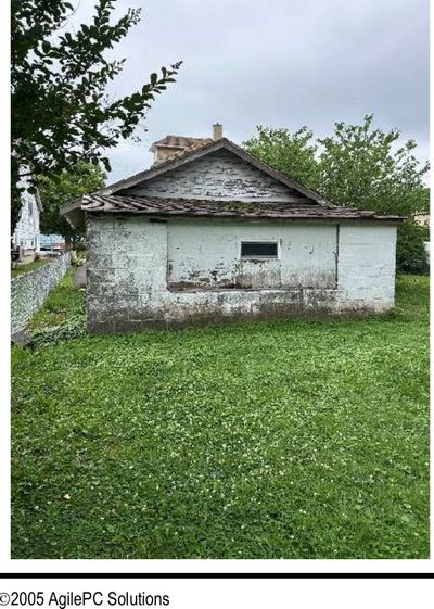 Deteriorated detached masonry garage with rotted walls and peeling finish behind a pre-war Willow Grove PA home, documented during a July 2026 home inspection