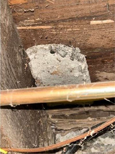 Suspected asbestos-containing insulation wrapping abandoned ductwork between the basement joists of an 80-year-old Germantown Philadelphia row home, found during a May 2026 home inspection