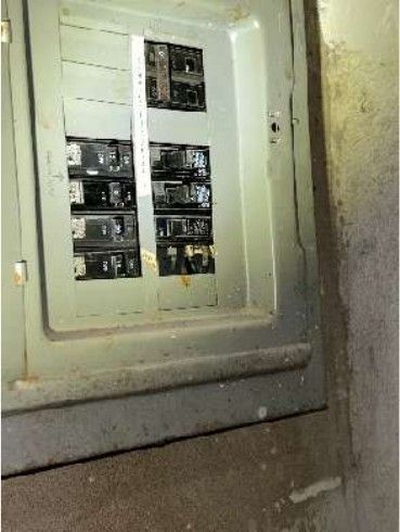 Cluttered basement utility area with an electrical panel in a converted multi-unit Fern Rock Philadelphia rowhome, documented during a home inspection