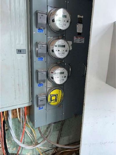 Multi-meter electrical bank in a mixed-use Fishtown Philadelphia rowhome with a missing house meter and open panel knockout, found during a May 2026 home inspection