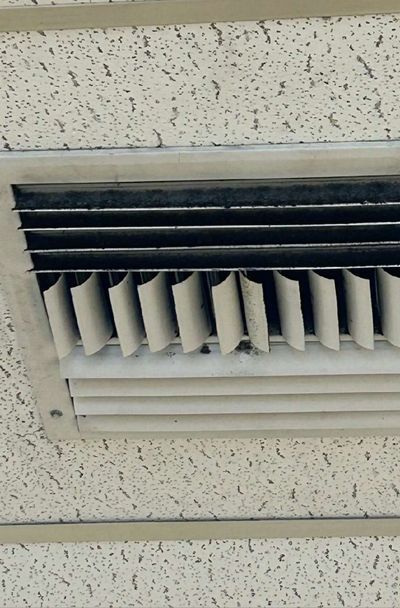 Dark mold growth across the vanes of an HVAC supply register in a commercial office suite in Aston, PA, documented during September 2026 mold testing
