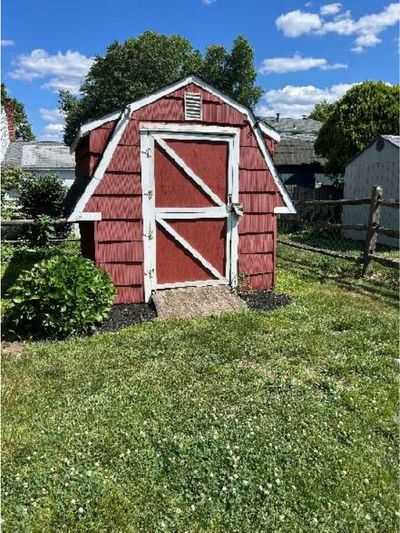 Detached backyard shed clad in asbestos-cement shingles at a Warminster PA home, identified during a June 2026 home inspection