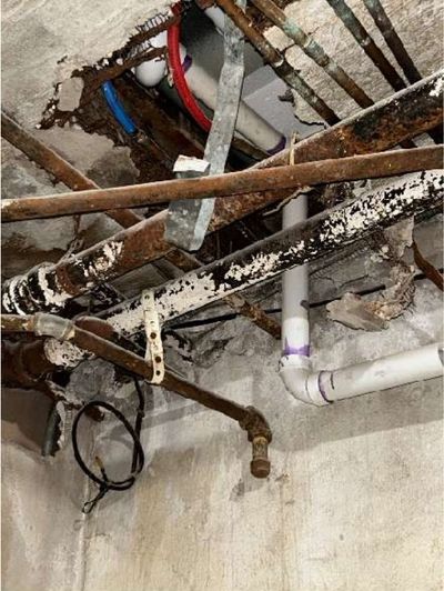 Corroded electrical equipment with open junction boxes and unsecured wiring in the basement of a converted Fern Rock Philadelphia rowhome, found during a home inspection
