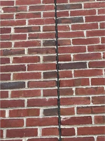 Open vertical mortar joint running up the front brick wall of a Port Richmond Philadelphia rowhome, documented during a June 2026 home inspection