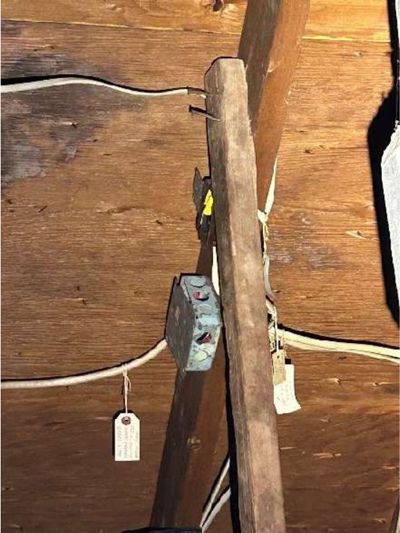 Open electrical splice left unprotected in the garage attic of a Warminster PA home, found during a June 2026 home inspection