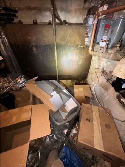 Large abandoned oil tank surrounded by stored clutter in a Northern Liberties Philadelphia storefront basement, documented during a May 2026 home inspection