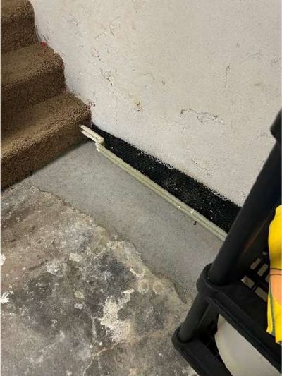 Exposed radiator heating pipes running along the base of a basement wall in a Roxborough Philadelphia home, documented during a June 2026 home inspection