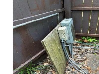 Pool electrical panel on an unsecured wooden support leaning against fence at Schwenksville PA home — home inspection June 2026 finding