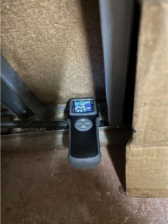 Moisture meter reading elevated dampness on a basement wall in a Yardley, PA home during a home inspection, confirming active wall moisture
