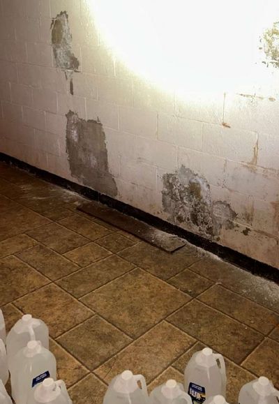 Dark water staining and discoloration on a painted block basement foundation wall in a Kennett Square PA home, found during a December 2025 mold test