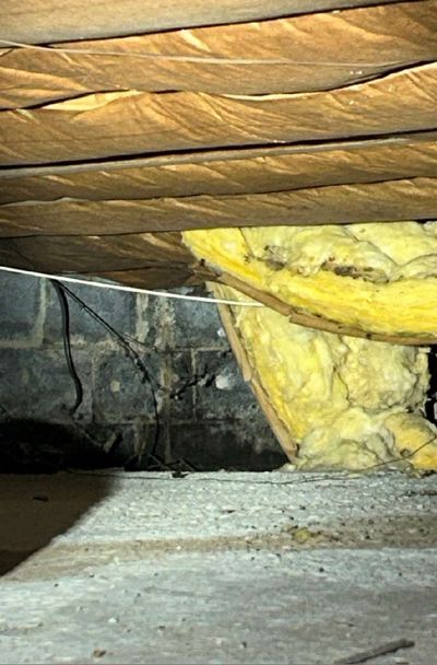 Batt insulation falling away from a crawl space foundation wall in an Ambler PA home, sagging from repeated moisture exposure
