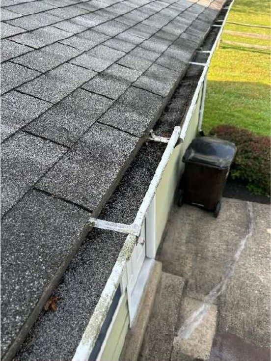 Deteriorated asphalt roof shingles and debris-clogged gutters on a Phoenixville, PA home, photographed during a home inspection